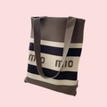 Detail of striped knit tote bag in brown and white featuring momio knitted text - Chocolate Mio Stripe