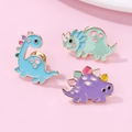 Trois pin's dinosaures mignons en émail bleu, vert et violet avec bordure dorée - Lot de 3 Broches Dinosaures (HP036)