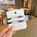 Large matte black and grey gradient hair clip with minimalist hollow rectangle design - White Ink Color