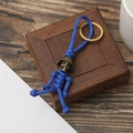 Detail of blue paracord skeleton keychain with brass helmet on a wooden box - Fluorescent Blue