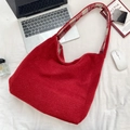 Borsa tote in lana rossa con tracolla a quadretti in un ambiente lifestyle casual - Rosso Natale