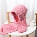 Detail of pink knitted hooded scarf with thick plush lining on a cozy wooden table - Peach Blossom Pink