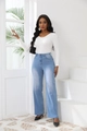 High-waist light blue flare jeans paired with a white long-sleeve knit top for women - S / Light Blue