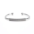 Detail of silver stainless steel open bangle featuring flexible spring coil and dual ball ends - Silver