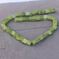 Close-up of green cube-shaped stone beads strung on a line for DIY jewelry making - Southern Jade