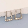 Detailed macro view of silver geometric hoop earrings with heart shaped bead accents - Silver Style K7-73