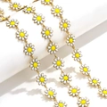 Detailed close-up of yellow and white enamel daisy chain links on golden base - Price per Meter / Gold-White