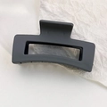 Detail of matte black rectangular hollow hair claw clip on white textured background - Grey Blue