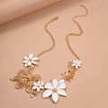Golden necklace with white enamel flowers and hollow floral pendants on a soft pink background - Gold