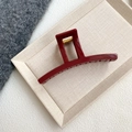 Detalle macro de la pinza de pelo roja grande con resorte dorado sobre fondo texturizado - Rojo Vino - Pinza Geométrica (12.8cm)
