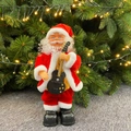Electric musical Santa Claus toy with black guitar standing by a Christmas tree - Santa with Guitar