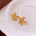 Makro-Detailansicht goldener Blumenohrstecker auf einem dekorativen weißen Keramiktablett - 13# Stahlstift - Goldene Texturierte Blumen-Ohrstecker