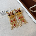Macro detail of Chinese lion dance earrings with enamel gold finish and red tassel beads - 15# Silver Needle - Drip Oil Zircon Lion Coin Tassel