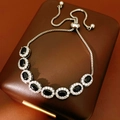 Dettaglio del bracciale regolabile in argento con sette zirconi blu ovali incastonati - Nero