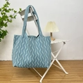 Detailed knit texture and blue wavy pattern of a large capacity tote bag on a chair - Vertical Stripe Blue