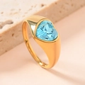 Titanium steel ring with gold finish and heart-shaped blue gemstone on stone background - Sky Blue