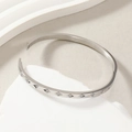 Polished silver titanium steel bangle featuring ten sparkling diamonds on stone base - Steel