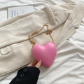 Mini sac à bandoulière rose en forme de cœur avec chaîne dorée sur fond neutre doux - Rose