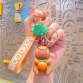 Cute brown capybara keychain holding orange with Lucky Day wrist strap and turtle charm - Resin Capybara - Persimmon