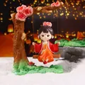 Cute Yang Yuhuan figurine in red Hanfu sitting on a rose swing with floral accents - Yang Yuhuan Swing Figurine