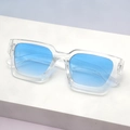 Detail view of stylish square sunglasses with transparent frames and blue gradient lenses - Clear Frame Blue Lens