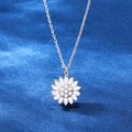Macro di un ciondolo a forma di girasole in argento con zirconi su velluto scuro - Platino / Argento