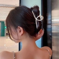 Detail of a large gold alloy hair claw clip with pearl inlays worn by a model - Sparkling Rhinestone Pearl Claw