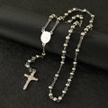 Macro view of silver bead chain necklace featuring Saint Benedict medal and crucifix - Steel