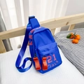 Blue nylon kids chest bag with red 21 lettering on a cozy white bed background - Large / Blue