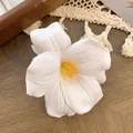Elegant white faux tulip hair clip with yellow pistil on rustic wooden background - Pure White