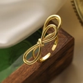 Bague ouverte nœud plaqué or 18 carats sur socle en bois sombre et tissu de soie - Style Noeud (14163)