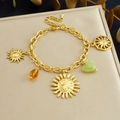 Dettaglio di un bracciale in acciaio inossidabile dorato con ciondoli sole e gemme - Bracciale B1833
