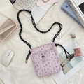 Close-up of small purple floral canvas crossbody bag on a white desk with lifestyle props - Floral Purple