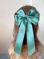 Elegant emerald green satin bow hair clip with long ribbons on light brown hair - Dark Green