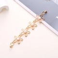 Detail view of golden flower chain with pearls and magnetic screw clasps on a beige surface - Hollow Flower Artificial Pearl Magnetic Chain (K545)