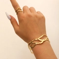 Bracciale rigido dorato stile lava con set di anelli ondulati abbinati da donna - Set Bracciale e Anello Traforato con Texture Lavica