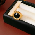 Close-up of vintage gold ring featuring a large black faceted gemstone on white velvet - Gold-Black