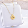 Golden necklace with a red gemstone pendant featuring a hollow sunburst design on a jewelry box - Light of Energy