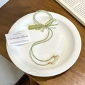 Light green silk hair tie with white lily of the valley flower on a white ceramic plate - FQ1064B Long Rope Lily of the Valley
