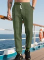 Dettaglio dei pantaloni jogger verdi da uomo con trama jacquard e coulisse bianca - Taglia S / Pantaloni e gonne / Verde militare