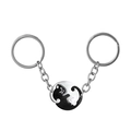 Close-up of black and white interlocking cat pendants with polished metal keychains - Round Black White Cat