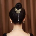 Elegante fermaglio a farfalla dorato con strass e nappe su una acconciatura a chignon - F0378 Farfalla con Frangia Oro
