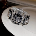 Macro detail of vintage floral bracelet with black gems and sparkling white rhinestones - Silver Base Black Rose Style