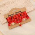 Böhmisches mehrlagiges Perlenarmband-Set in Rot und Gold auf Vintage-Karton - Rot
