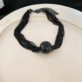 Detailed view of multilayer black metal chains and a large round sphere pendant - Necklace-Black
