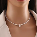 Detail of shell beaded necklace with gold heart and letter B charm on model - Letter B