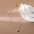 Detail of gold necklace with purple zircon pendant displayed on a geometric prop - February Amethyst Purple Zirconia