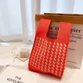 Orange-weiß karierte Stricktasche mit Hahnentrittmuster und gewebtem Tragegriff - Koralle
