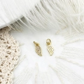 Macro view of gold angel wing charms with crystal inlay on soft feather background - Wing