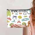Detail of canvas pouch with black zipper and 'HAIR STUFF' print and hair accessory patterns - Hair Stuff Storage Style